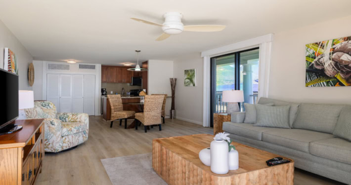 Interior with separate seating and coffee table, dining area, kitchen and television in mountain view unit