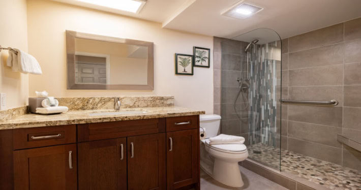 updated modern bathroom with walk-in shower, large mirror